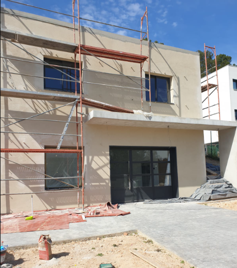 Fachada de la vivienda en Corbera de Llobregat con andamios durante la preparación de la superficie
