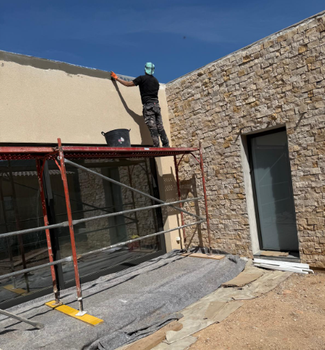 Operario de Reformas Fortek aplicando el acabado acrílico sobre la fachada