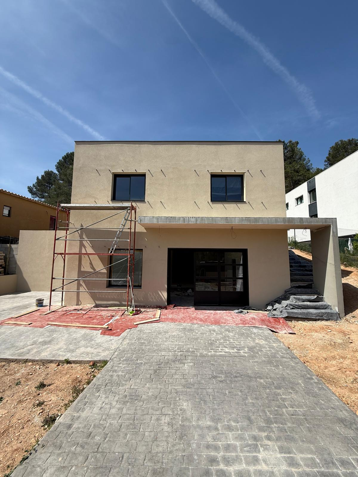 Fachada de vivienda unifamiliar en Corbera de Llobregat tras la finalización del acabado acrílico en dos colores