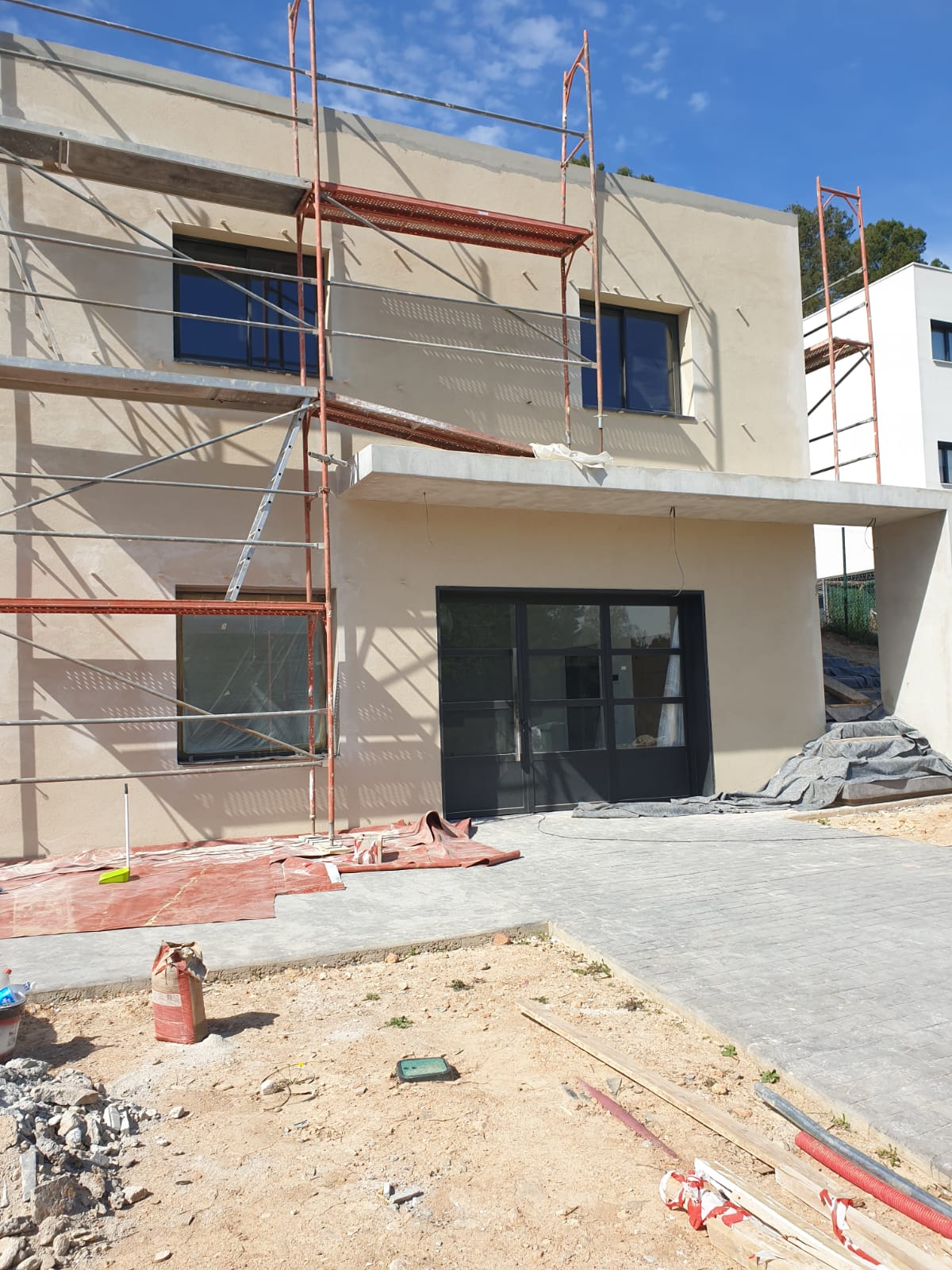 Vivienda unifamiliar de obra nueva con andamio y fachada en acabado